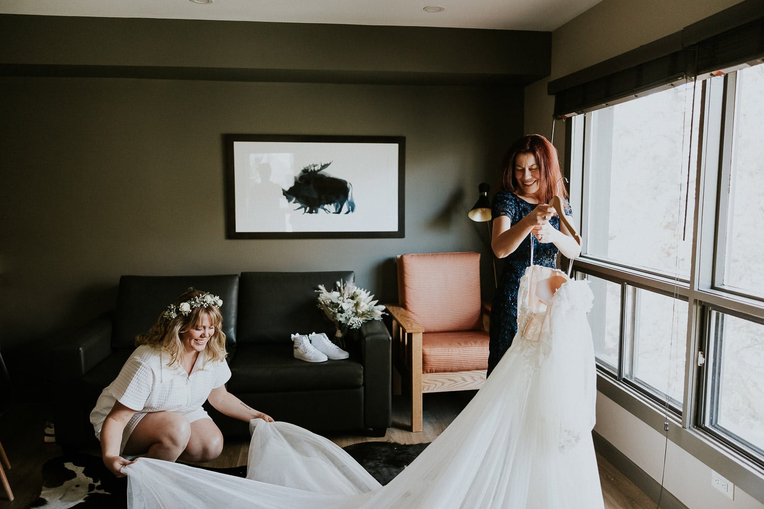 bride and mother of the bride getting her wedding dress ready to put on in Banff Alberta