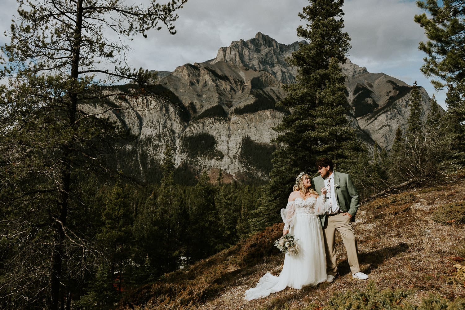 bride and groom standing in front of a mountain in Banff Alberta