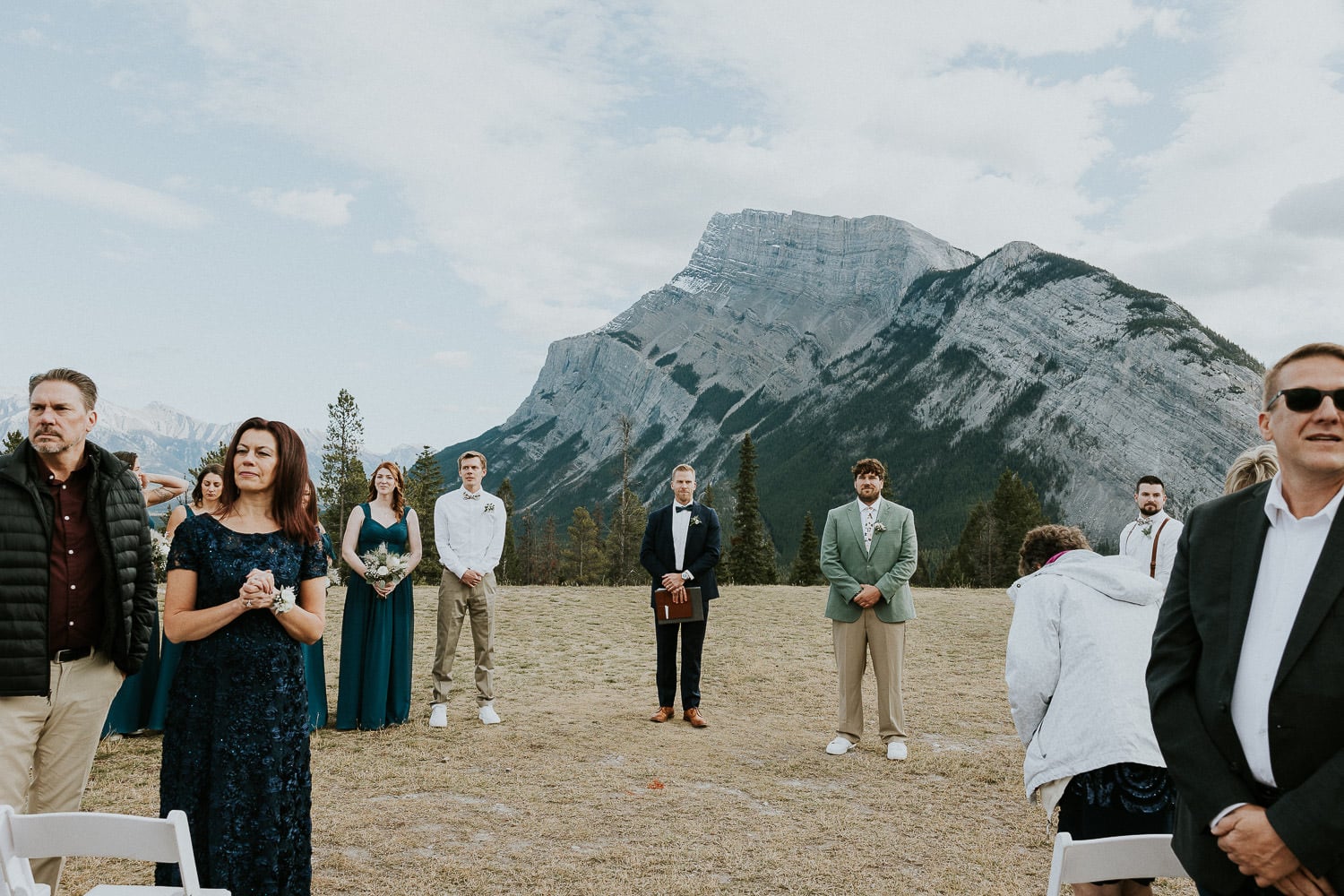 grooms reaction to the bride coming down the aisle at their outdoor wedding in Banff