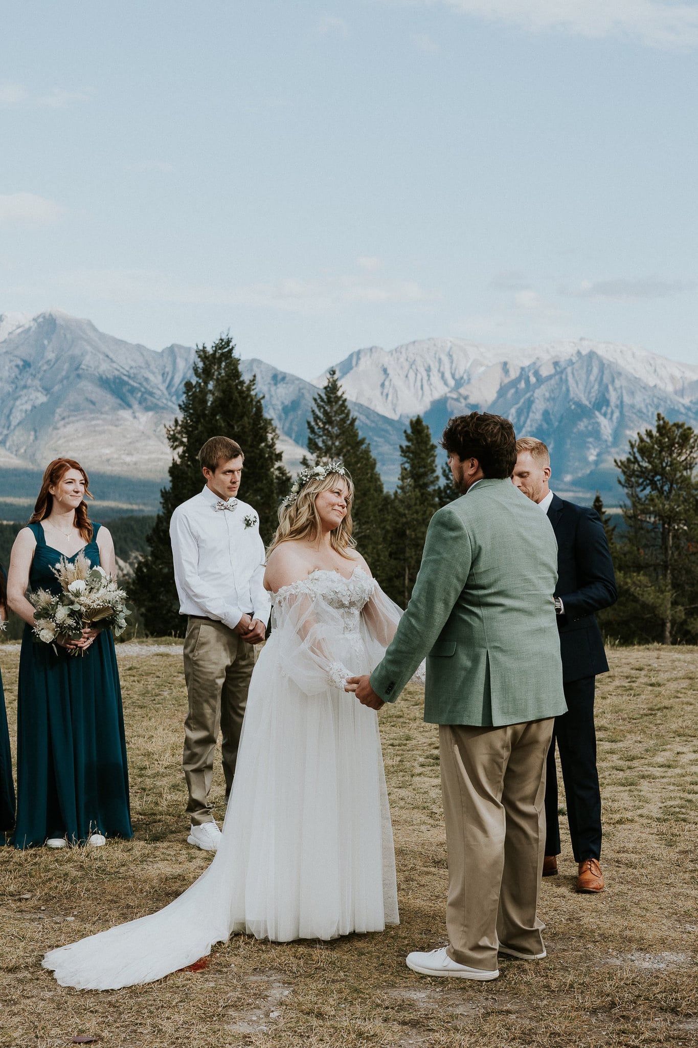 bride holding hands with groom at tunnel mountain wedding ceremony in Banff Alberta