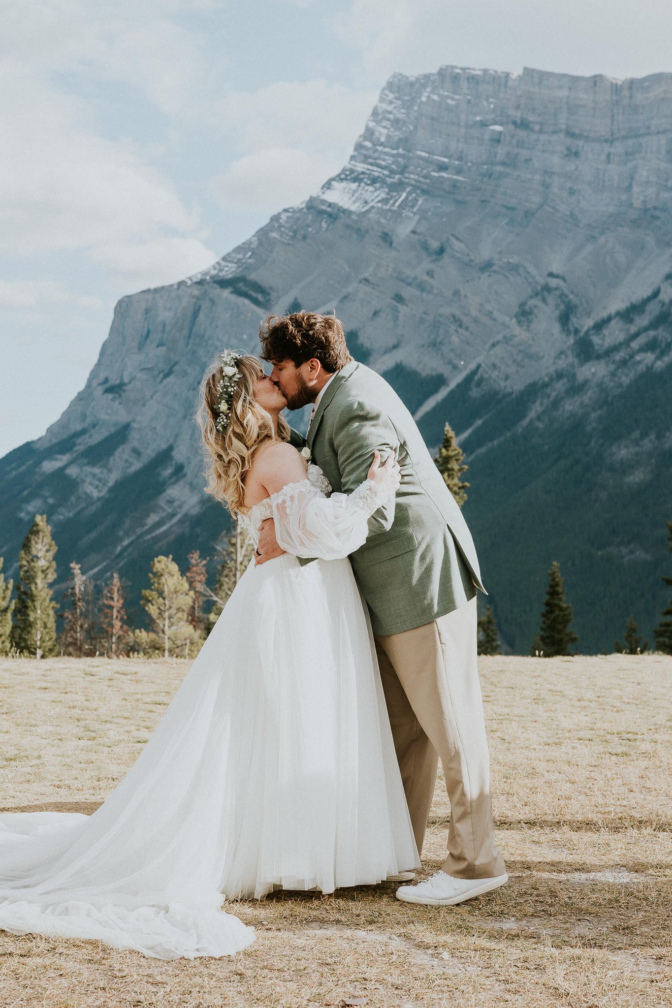 bride and groom do their first kiss at tunnel mountain wedding ceremony in Banff Alberta
